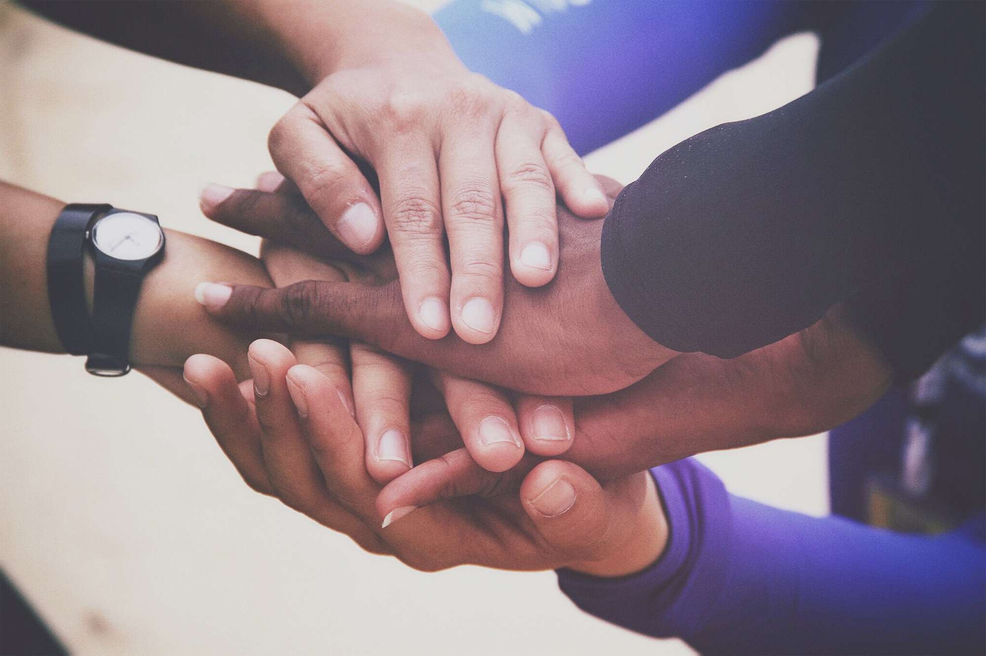 Diverse group of people holding hands in supportive gesture